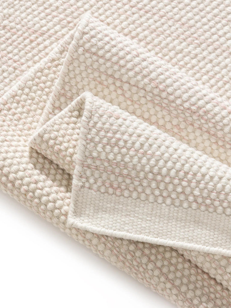 Tapis scandinave tressé enfant crème et corail en laine 90x130 cm