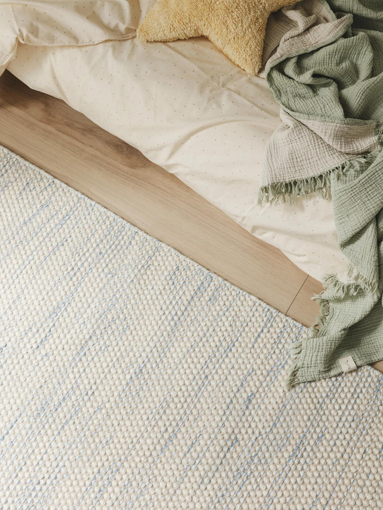 Tapis scandinave tressé enfant blanc et bleu en laine 90x130 cm