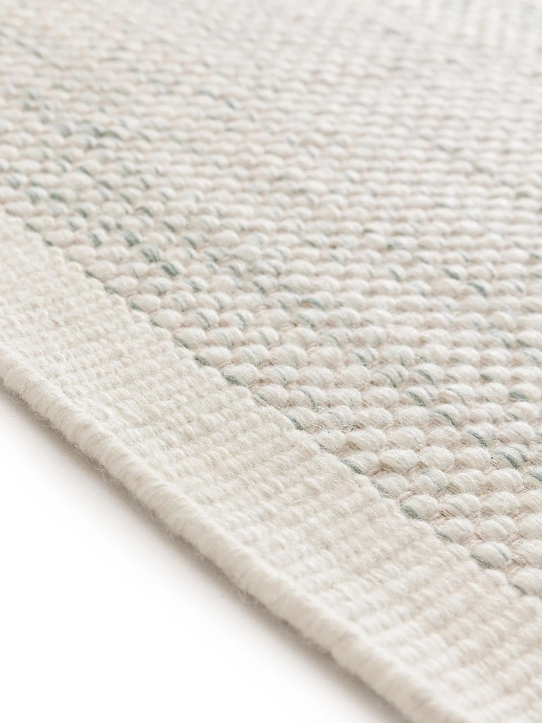 Tapis scandinave tressé enfant crème et gris en laine 90x130 cm